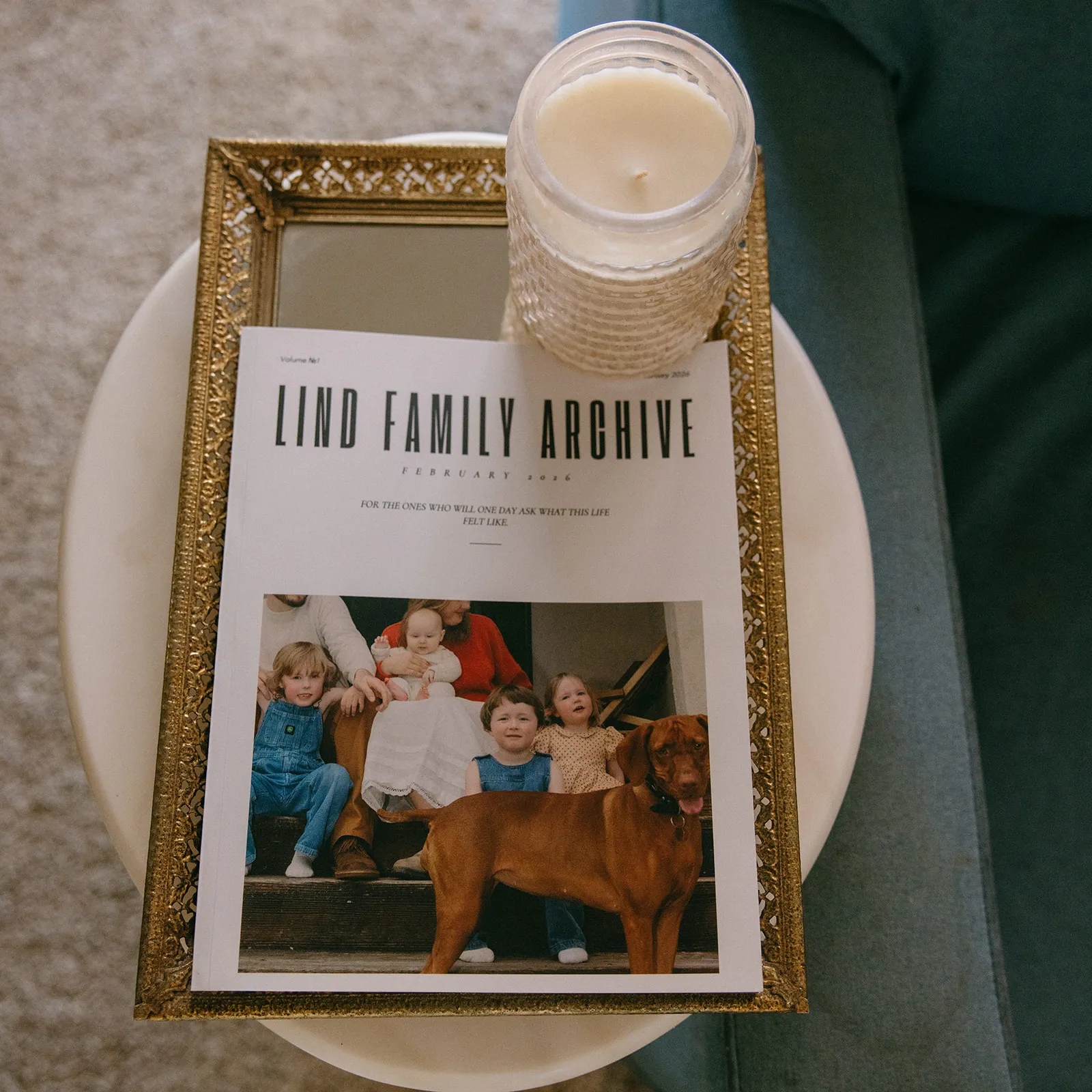 A printed Family Archive resting on a table beside a candle