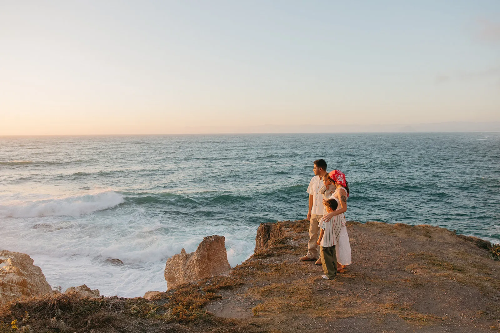 A family standing together above the water at golden hour